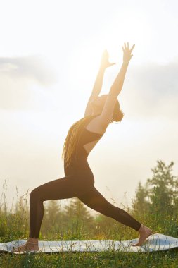Doğada yoga minderine adım atan bir kız..