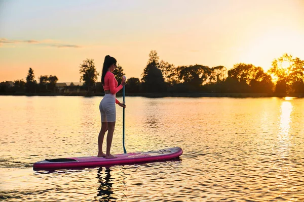 Sportieve vrouw oefenen in sup boarding op de stad meer — Stockfoto