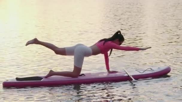 Fitness vrouw doet evenwichtsoefeningen op sup board — Stockvideo