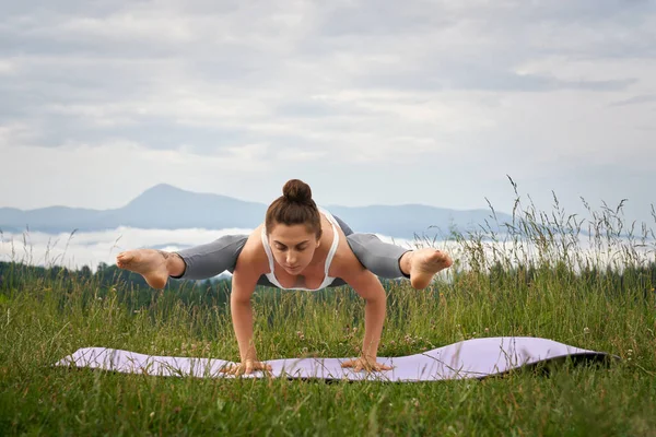 Donna in abiti sportivi che fa esercizio di yoga all'aria aperta — Foto Stock