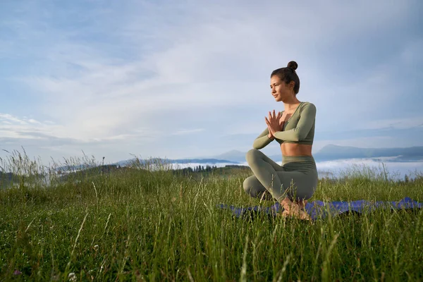 Donna pacifica in abiti sportivi praticare yoga all'aperto — Foto Stock