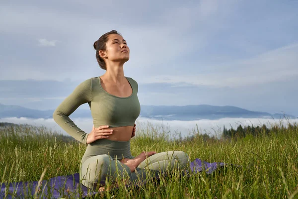 Donna in abiti sportivi godendo di armonia durante l'allenamento — Foto Stock