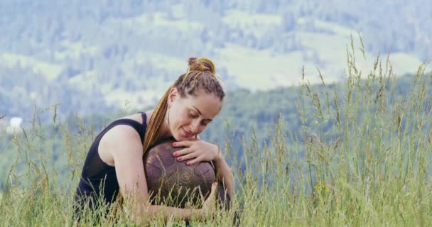 Femme avec tambour suspendu tout en se relaxant dans les montagnes — Video