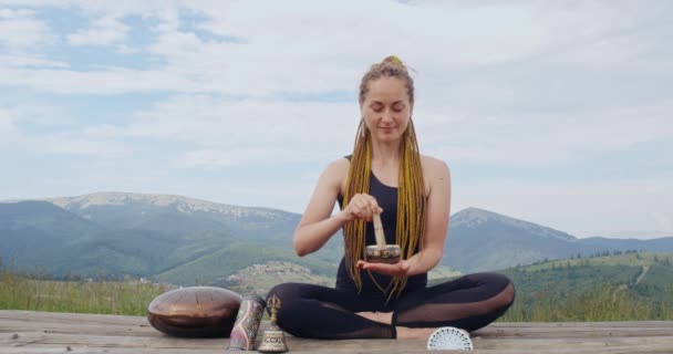 Mulher jogando no tibetano cantando tigela em pose de lótus — Vídeo de Stock