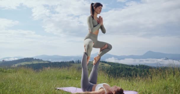 Spor yapan kadınlar temiz havada akrobatik yoga yapıyorlar. — Stok video