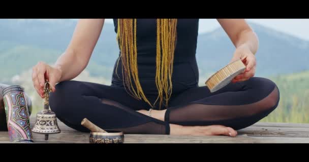 Frau benutzt Musikinstrumente beim Yoga im Freien — Stockvideo