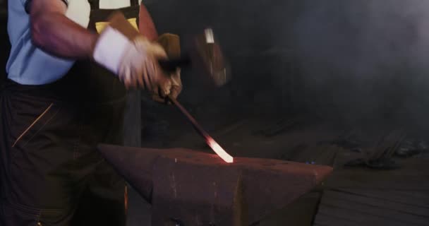 Blacksmith holding red iron stick by hands. — Stock video