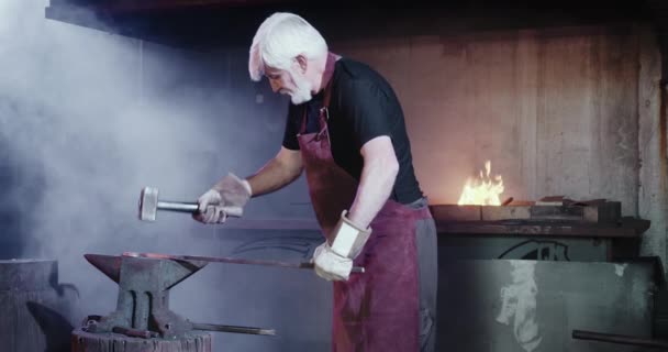 Blacksmith forging sword in mastershop. — Stock video