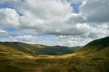 Kümülüs bulutları mavi gökyüzünü geçerken otlaklarda gölgeler bırakır..