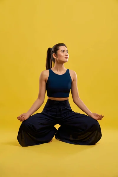 Sporty Girl sitter med bøyde bein, yoga gjør. – stockfoto