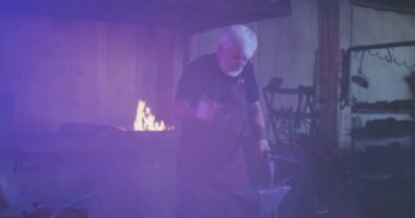 Demirci karanlık demircide çalışıyor..