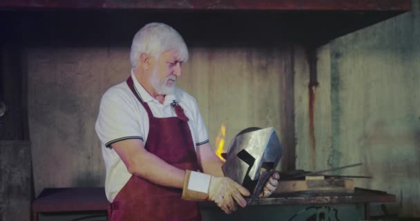 Blacksmith steel black helmet holding. — Stock video