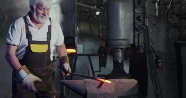 Blacksmith creating metalwork in mastershop. — Stock video