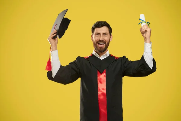 Happy student holding diploma and mortarboard. — стоковое фото