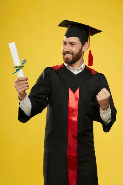 Šťastný student s minometem držící diplom. — Stock fotografie