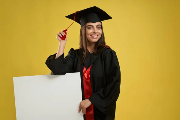 Charming female standing, showing mortarboard. — Stockfoto