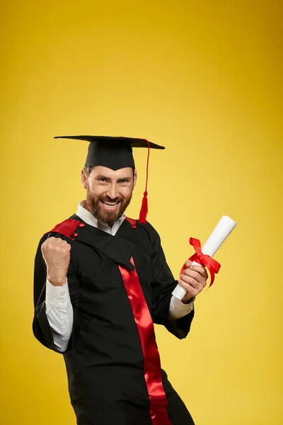 Hezký mladý muž držící diplom. — Stock fotografie