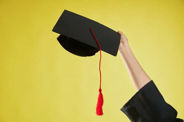 Female hand raising, holding, showing mortarboard. — Foto Stock