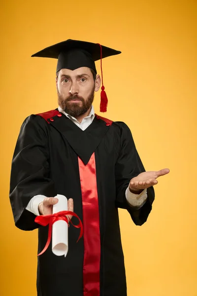 Young male holding, showing diploma, asking. — Foto Stock