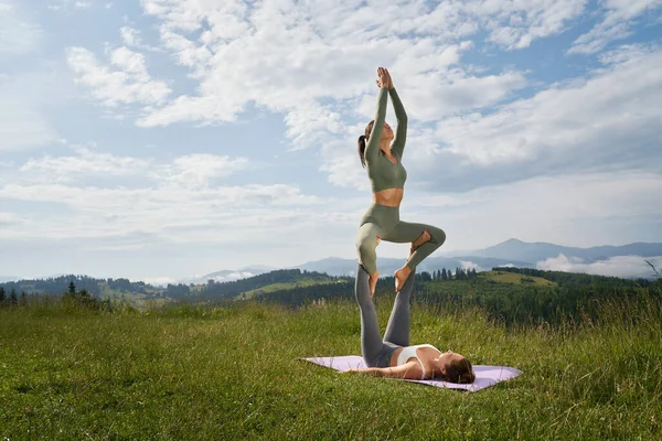 Donne che fanno ashtanga yoga insieme mantenendo l'un l'altro. — Foto Stock