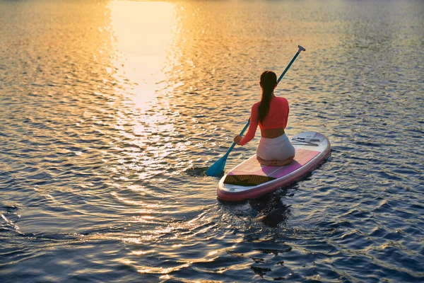 Woman spending evening time for practising in sup boarding — Fotografia de Stock