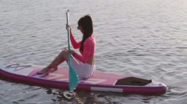 Güzel bir kadın akşam sporunu raket tahtasında yapıyor.