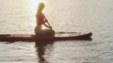 Sportif kadın uzun kürekle yemek masasında yüzüyor.