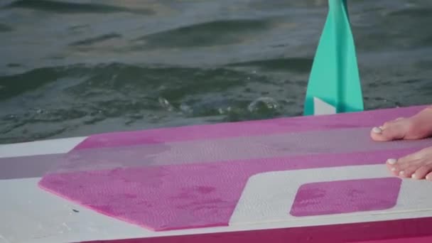 Primer plano de la mujer flotando en sup board con descalzo — Vídeo de stock
