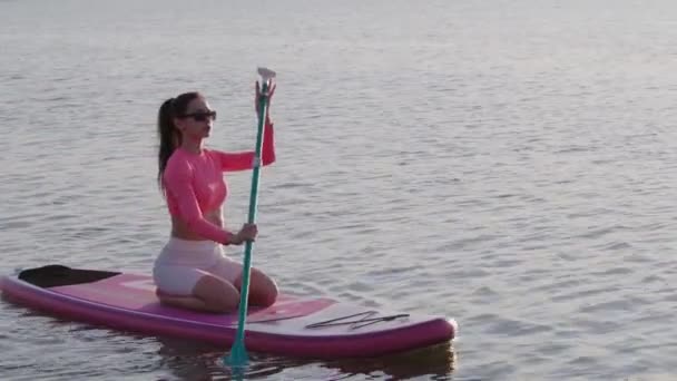 Спортивная женщина плавает на веслах на городском озере — стоковое видео