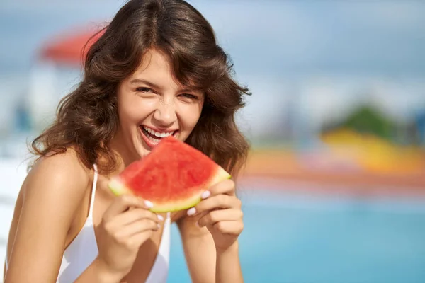 Feliz wavy haired fêmea sorrindo em prazer, enquanto mordendo melancia fora. — Fotografia de Stock