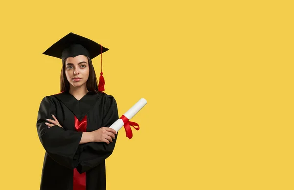 Hezká dívka se zkříženýma rukama, držící diplom. — Stock fotografie