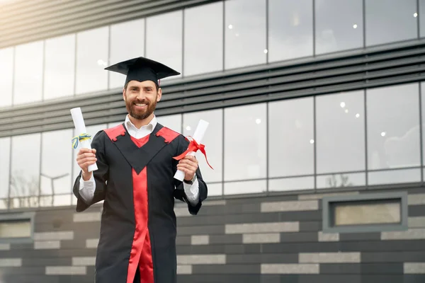 Studentin mit Masterabschluss, zwei Diplome in der Hand, lächelnd. — Stockfoto