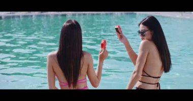 Bikinili kadınların bikinili havuz kenarında karpuz yediği arka manzara