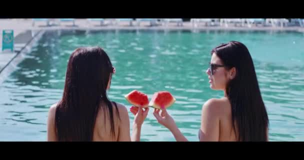 Gorgeous women enjoying watermelon near outdoors pool — Stock Video