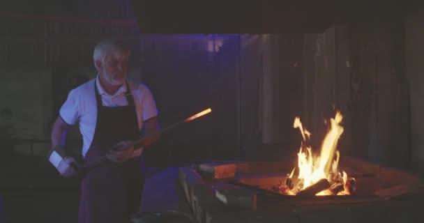 Starý kovář pracující v mistrovské dílně. — Stock video