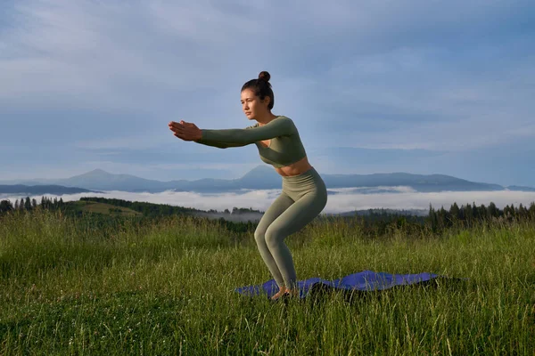 Affascinante donna in abbigliamento sportivo avendo mattina yoga all'aperto — Foto Stock
