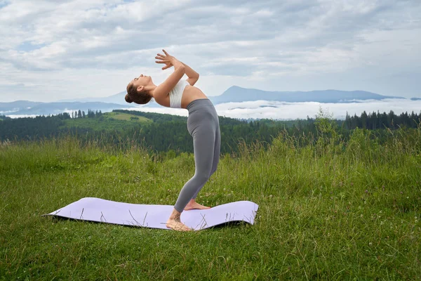 Donna attiva in costume sportivo praticare yoga sulla natura — Foto Stock