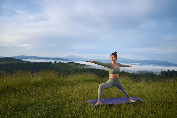 Persona femminile attiva che fa esercizi di yoga all'aperto — Foto Stock
