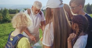 Etrafta dikilen, dinleyen, arayan, elinde harita olan yaşlı bir adamın görüntüsü. Seyahat eden turistler, birlikte yürüyüş yapanlar. Turizm ve takım ruhu kavramı