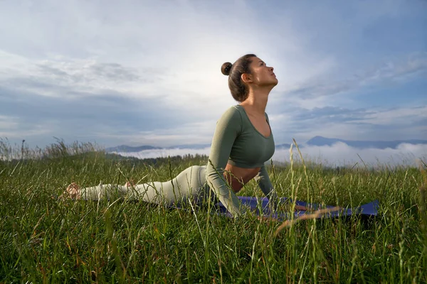 Brunette woman doing Surya Namaskar in mountains. — Stock Photo, Image