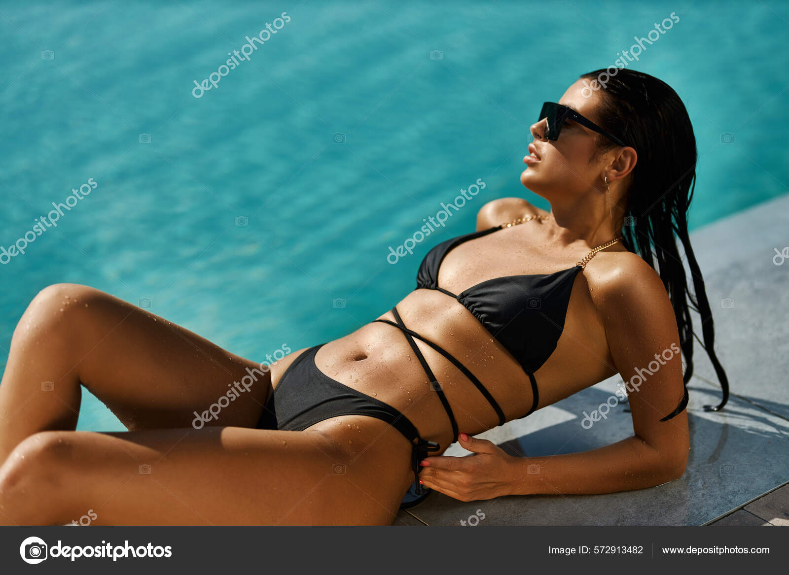 Gorgeous wet girl in a black bathing suit enjoying the sun Stock Photo