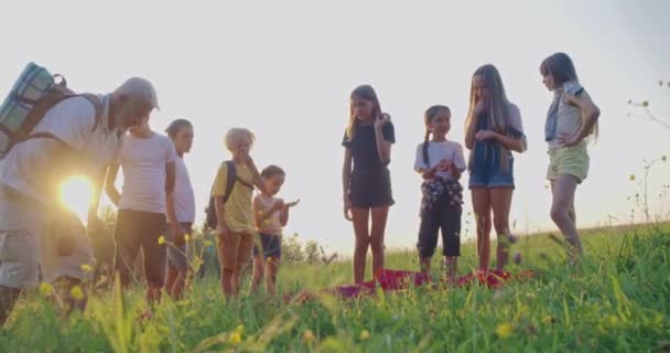 Tiener opzetten rugzaktent met volwassen instruktor op het veld. — Stockvideo