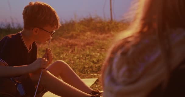 Tiener jongen probeert geroosterde marshmellow op de camping. — Stockvideo