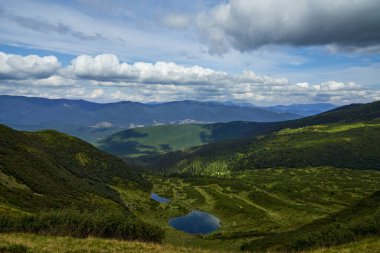 Uzak yüksek rakımlı küçük göller, otlak vadide, dağlar arasında.. 