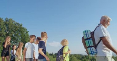 Gençler sıcak yaz gününde dağlarda yürüyüş yapıyorlar..