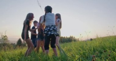Genç kızlar kamp alanındaki çayırlarda zıplayıp oynuyorlar..