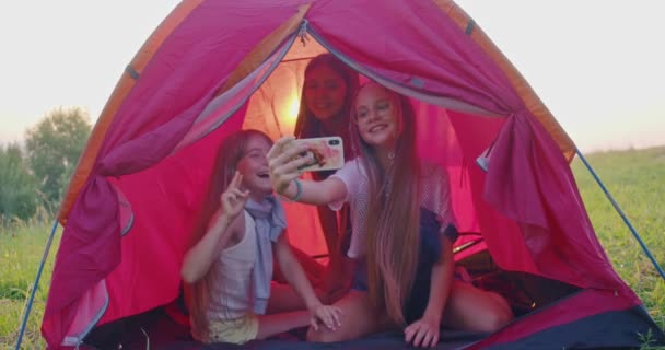 Quatro adolescentes fazendo selfie na tenda do acampamento nas montanhas. — Vídeo de Stock