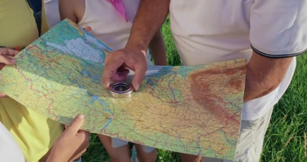 Grupo de turistas verificando rota no mapa no campo. — Vídeo de Stock