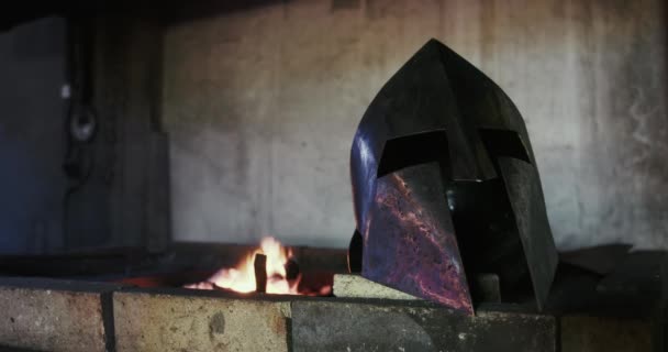 戦闘中の保護のための騎士ヘルメットマスクのフロントビュー 中世の鋼 炉で燃焼火災 職人技の概念 — ストック動画