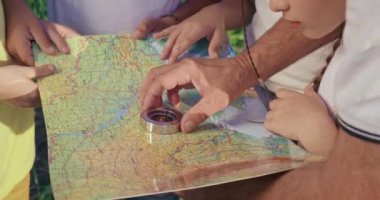 Pusula kullanarak yaşlı adama yaklaş, çocuklarla güzergahı ara, bak, ayakta dur, haritayı tut. Dağlarda birlikte yürüyüş yapan gezginler. Seyahat ve takım ruhu kavramı.